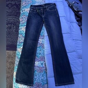 Low cut jeans jeans from early 2000s that have been packed away in closet.